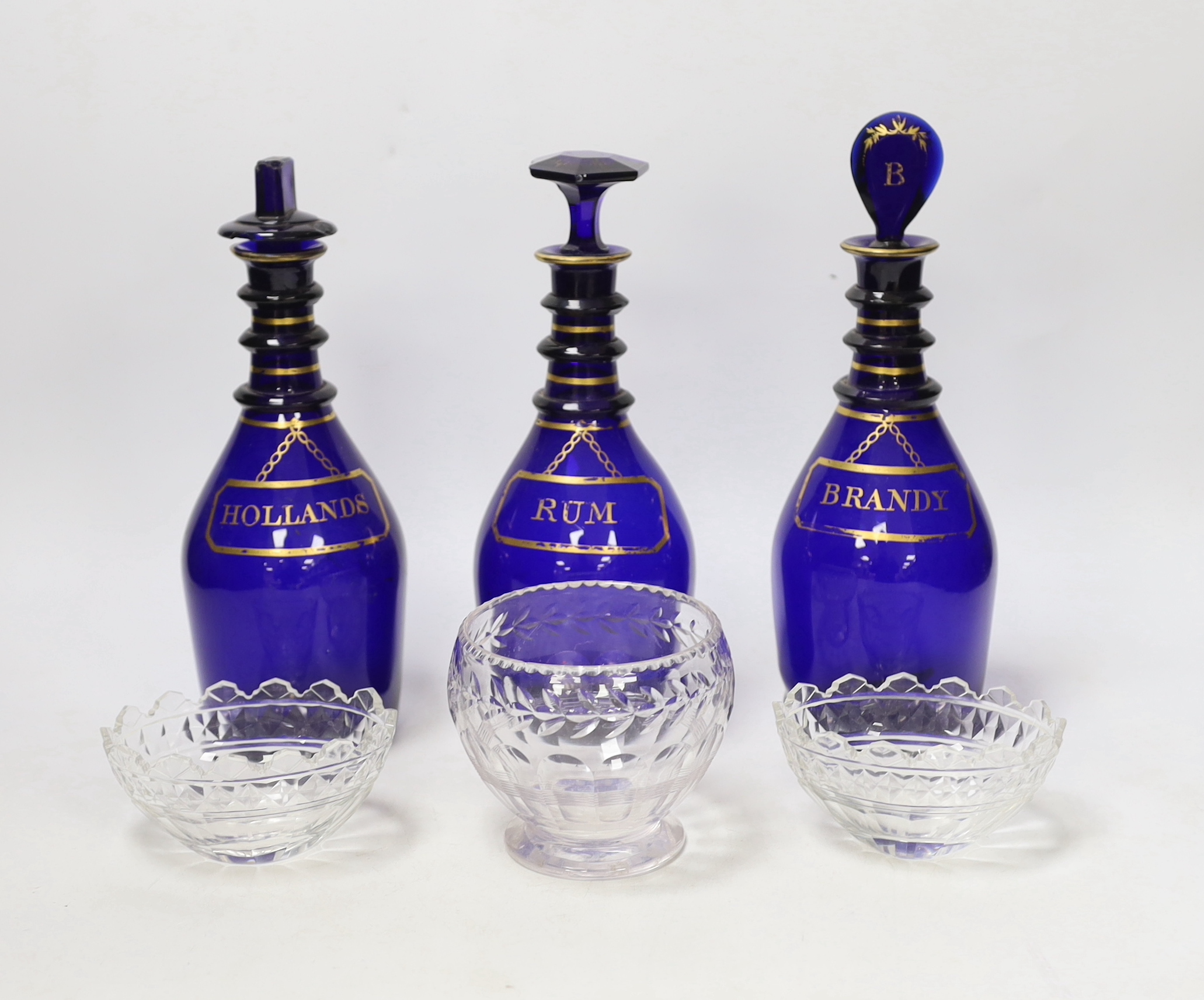 A set of three George III Bristol blue glass decanters, 25cm, and three small 19th century cut glass bowls